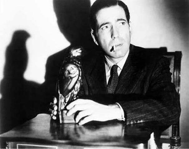 Humphrey, um dos maiores atores da história, desperdiçou boa parte da vida em nome do vício. Ele fumava não apenas nos filmes, mas na vida real. E fumou tanto que o câncer o matou cedo, aos 57 anos.  -Divulgação O Falcão Maltês 