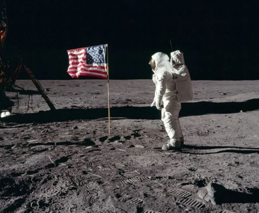 Nessa foto, Buzz Aldrin aparece diante da bandeira dos Estados Unidos, fincada na Lua.  Na mesma missão estavam Neil Armstrong, primeiro homem a pisar na Lua, e MIchael Collins, que não saiu da nave. -Nasa Domínio público