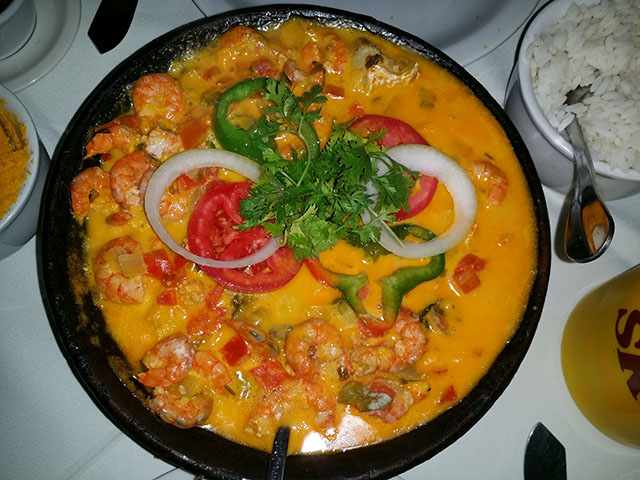Moqueca baiana: Um prato de peixe cozido com azeite de dendê, leite de coco, cebola, tomate e pimentão, cheio de sabores marcantes. Geralmente servido com pirão e arroz. Calorias: cerca de 170 kcal.