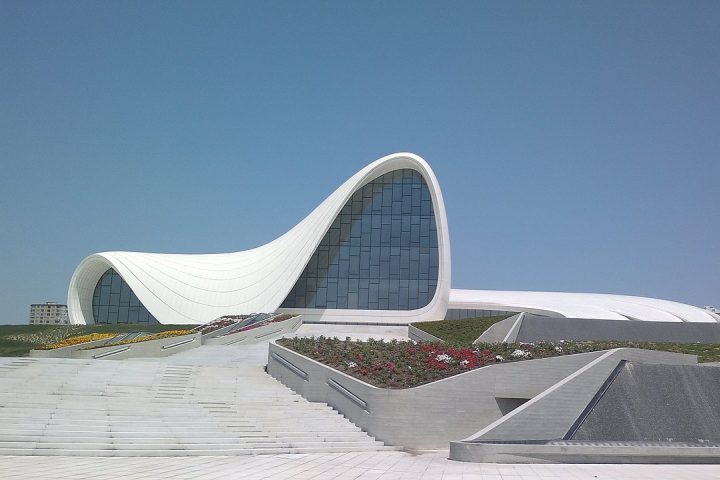 Outro marco arquitetônico é o Centro Heydar Aliyev, obra da arquiteta Zaha Hadid, cujas formas fluidas e ausência de ângulos retos desafiam a percepção tradicional do espaço. O edifício tornou-se um dos maiores símbolos do urbanismo contemporâneo da cidade.