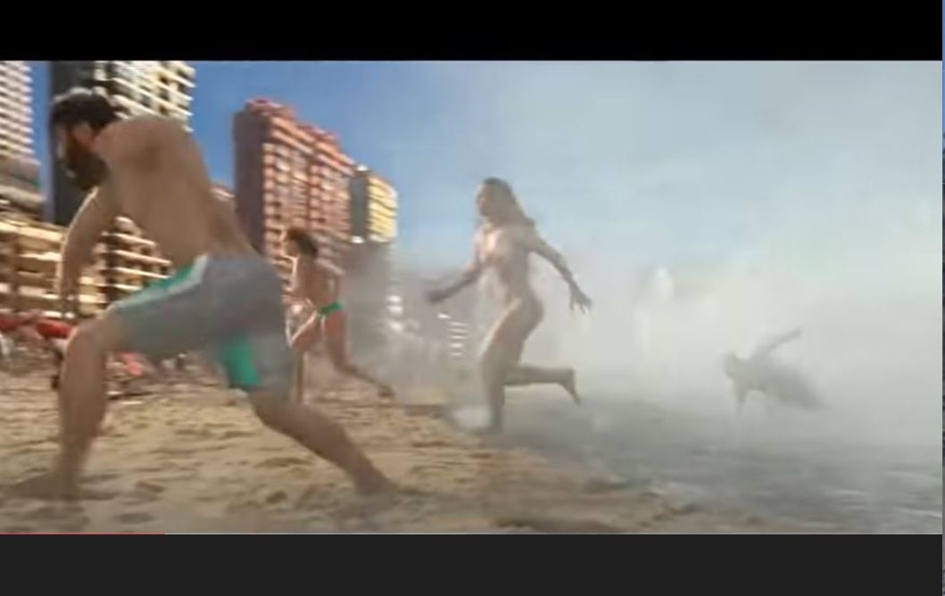 E uma onda de gelo invade a cidade, chegando pelo mar e invadindo a areia da praia, causando correria e pânico. -reprodução de cena