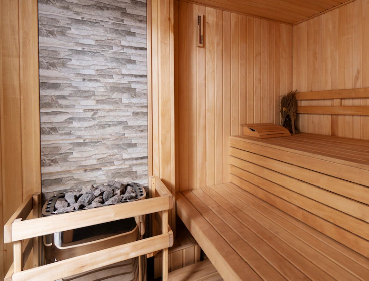 As saunas costumam ter uma cesta de pedras quentes junto da fornalha, onde se joga água pra aumentar a umidade do ar.-freepik
