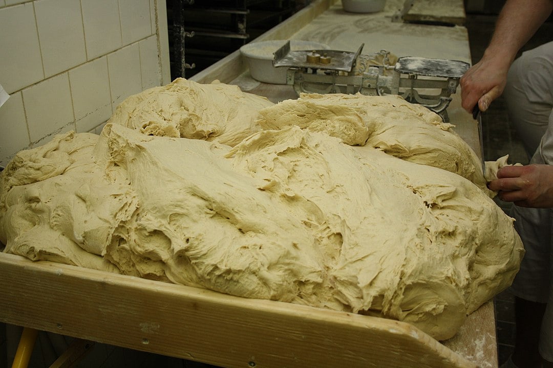 Nas padarias, uma grande massa é preparada e os pãezinhos são cortados para irem ao forno. 