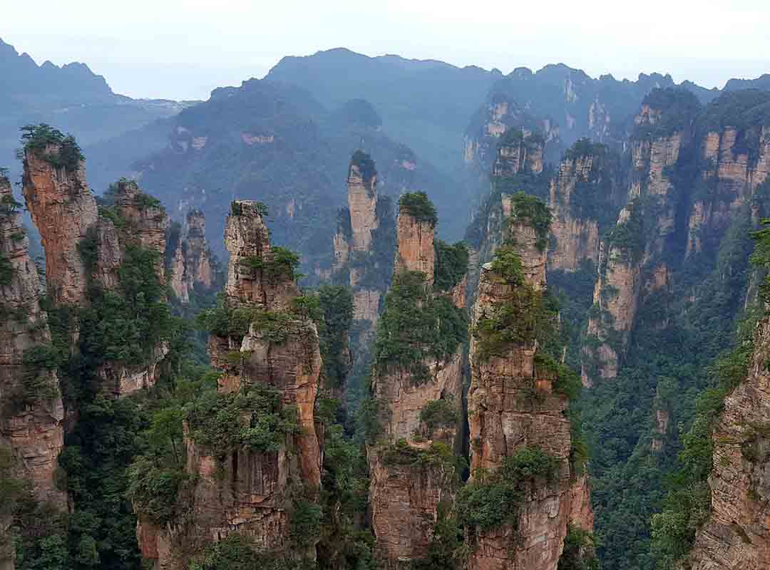 Zhangjiajie, China: Essas formações são mundialmente famosas por sua beleza e singularidade. Localizado na província de Hunan, o Parque Nacional de Zhangjiajie é conhecido por suas colunas de pedra de quartzito que se erguem verticalmente da terra, criando um cenário de tirar o fôlego.