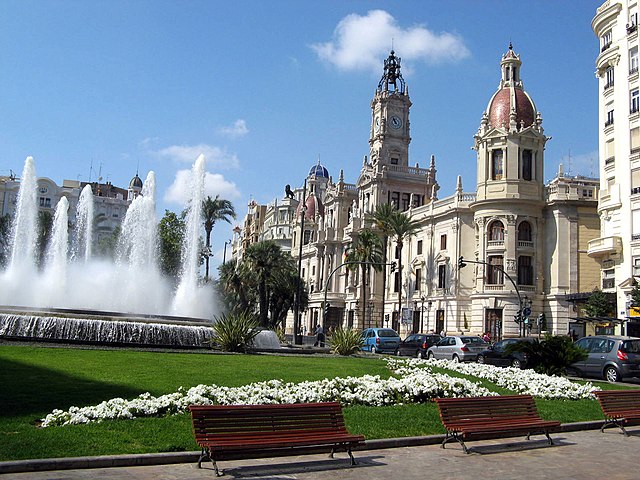 Em Valencia, a Plaza_del_Ayuntamiento (Praça da Câmara Municipal) tem edifícios em estilo eclético erguidos na primeira metade do século 20, inclusive a Câmara Legislativa da cidade. E ali destacam-se ainda uma fonte circular e esculturas. -I, Demiannnn wikimedia commons