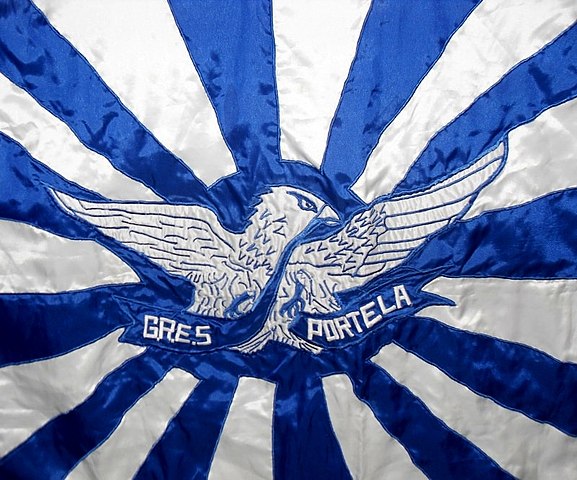 <p>Inspirada na Bandeira do Sol Nascente, que o Japão utilizava até o fim da Segunda Guerra Mundial, a bandeira definitiva da Portela foi criada em 1931 por Antônio Caetano, um desenhista da Marinha e um dos fundadores da escola.</p>
