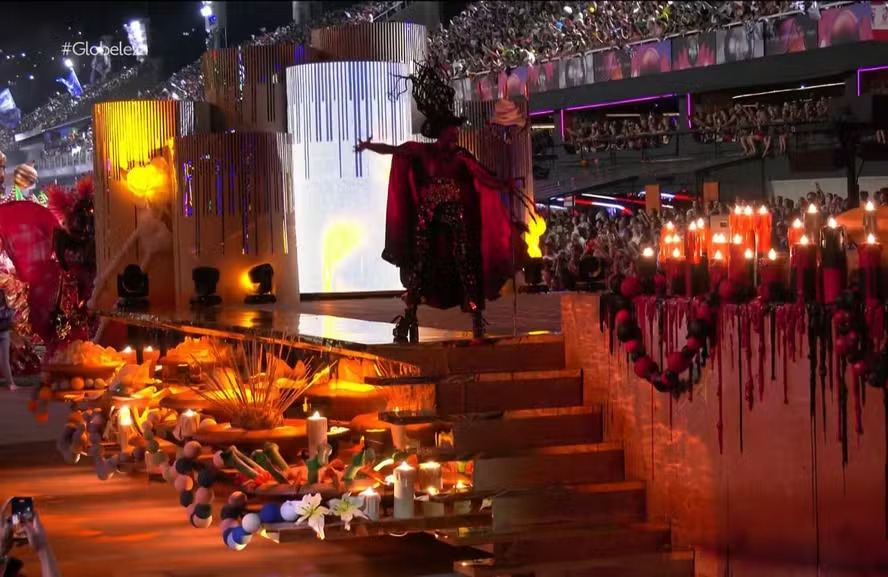 <p>Em 2025, a comissão de frente da Beija-Flor teve show de efeitos e velas que formavam nome de Laíla, um nome lendário da escola de Nilópolis. </p>
