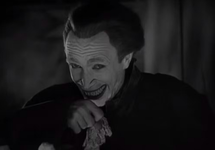 Como punição pelo erro do pai, o rosto de Gwynplaine é deformado, deixando um sorriso permanente em sua face. 