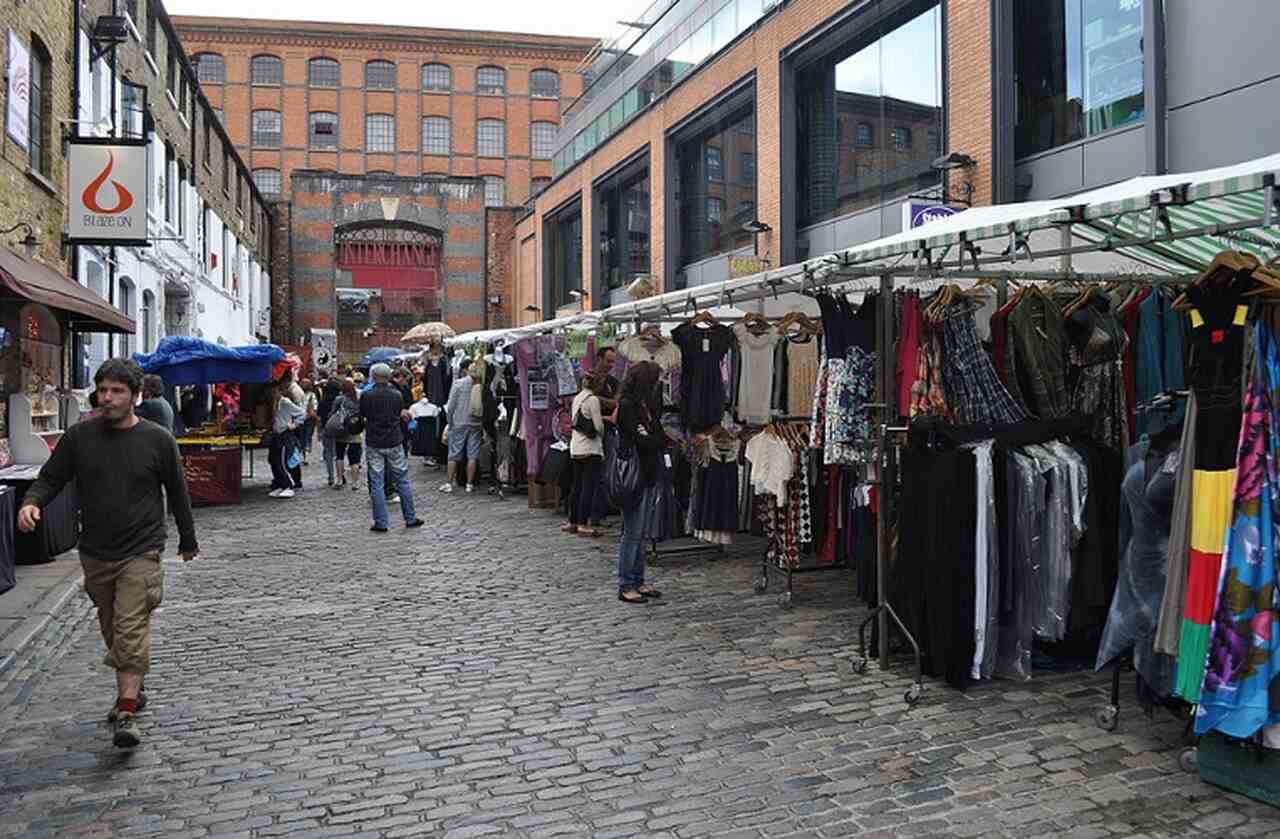 Camden Market - Descrição: Fundado na década de 1970, Camden Market é um dos mercados mais vibrantes e ecléticos de Londres, conhecido por suas bancas de roupas, comida de rua e itens artesanais - Localização: Camden Town - Referências Históricas: Camden Town tem sido um centro de contracultura e música alternativa desde os anos 1960-Lewis Clarke/Wikimedia Commons