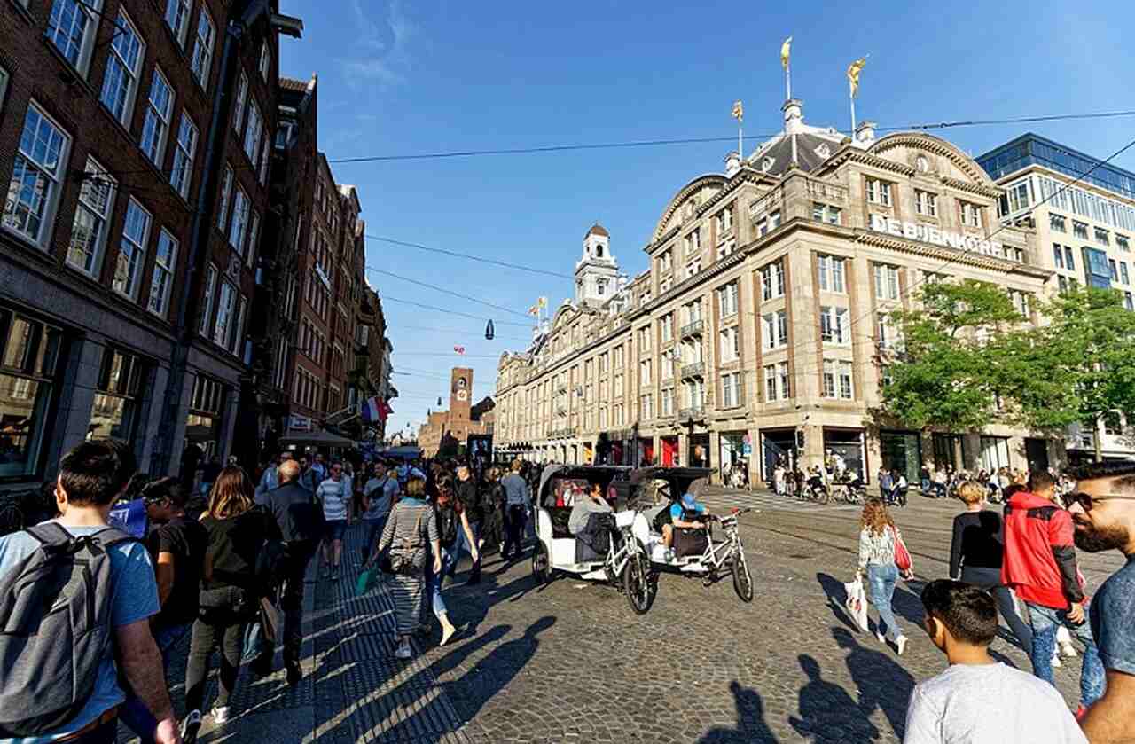 Praça Dam (Dam Square) - Descrição: Esta é a praça central de Amsterdã, estabelecida no século XIII, onde a cidade começou a se desenvolver - Abriga o Palácio Real, a Nova Igreja (Nieuwe Kerk) e o Monumento Nacional - Localização: Centro de Amsterdã - Referências Históricas: A praça foi o ponto de encontro para muitos eventos históricos, incluindo protestos e celebrações - Txllxt TxllxT/Wikimedia