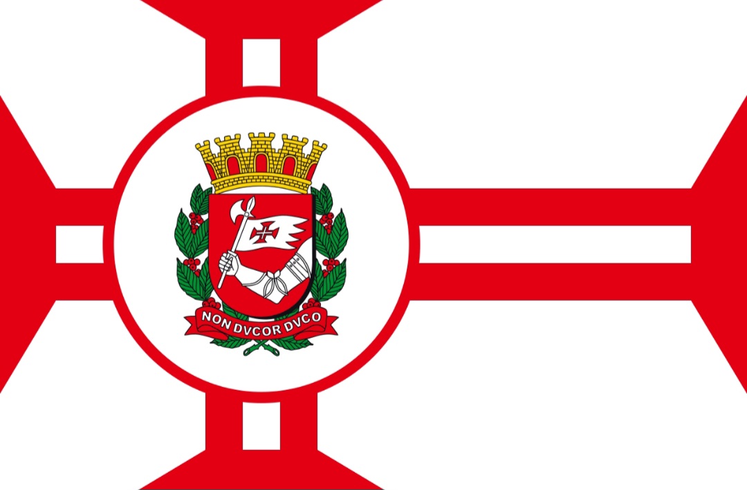 A bandeira da cidade de São Paulo é retangular branca e traz a Cruz da Ordem de Cristo em vermelho em braços alargados. Além disso, ostenta o brasão do município no centro sobre círculo de branco que está debruado de vermelho.
-Domínio público 