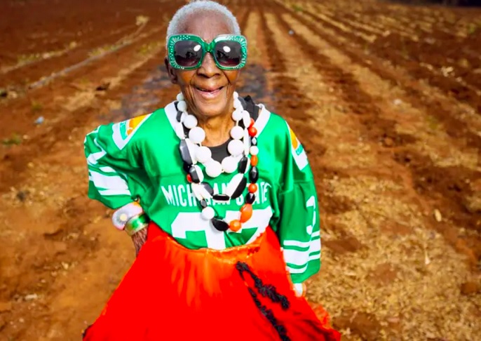 Os looks de Chola variam de homenagens às cores da bandeira da Zâmbia a combinações ousadas, como um top com lantejoulas e acessórios chamativos.