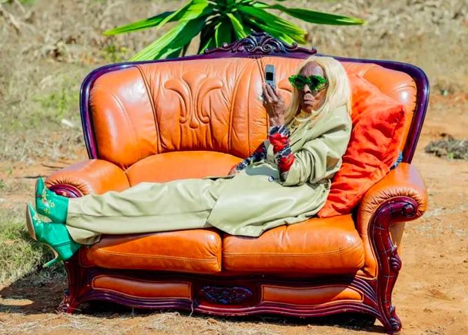 Dona Margret Chola é frequentemente fotografada ao ar livre em cenários rurais, exibindo sua elegância em meio a plantações e construções de tijolos, com direito à sofá de couro e tudo.