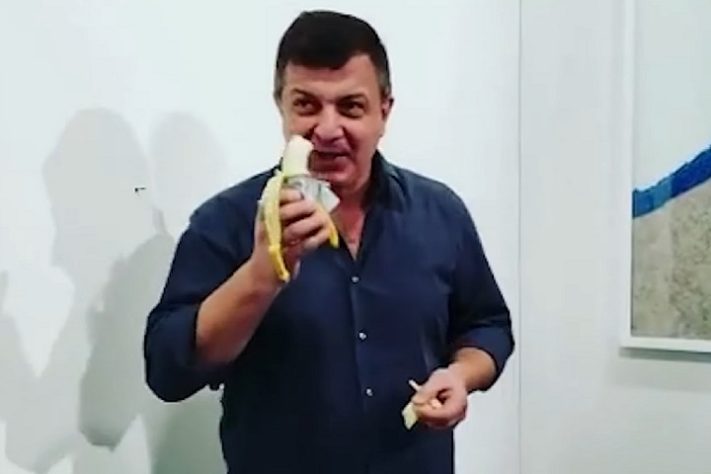 Homem come obra de arte banana colada na parede