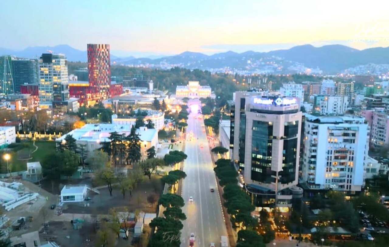 No campo do turismo, a Albânia tem se tornado um destino crescente, com sua capital Tirana passando por uma renovação significativa desde os anos 2000. O ex-prefeito da cidade, Edi Rama, que também é artista, liderou um movimento de embelezamento da cidade, transformando prédios cinzentos da era comunista em obras vibrantes de arte pública.-Youtube/Exploropia
