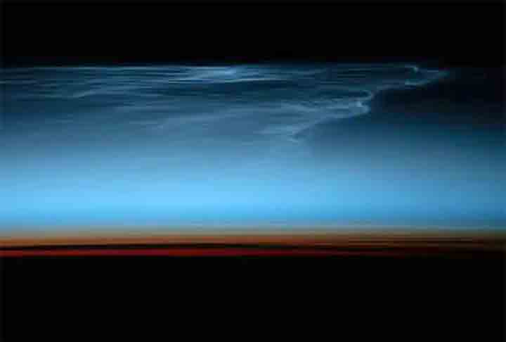 Nuvens noctilucentes tênues na atmosfera superior da Terra são iluminadas pela luz do sol logo após o pôr do sol acima do Oceano Pacífico Sul. Algo extremamente raro, já que são mais altas na atmosfera do que qualquer outra nuvem.

