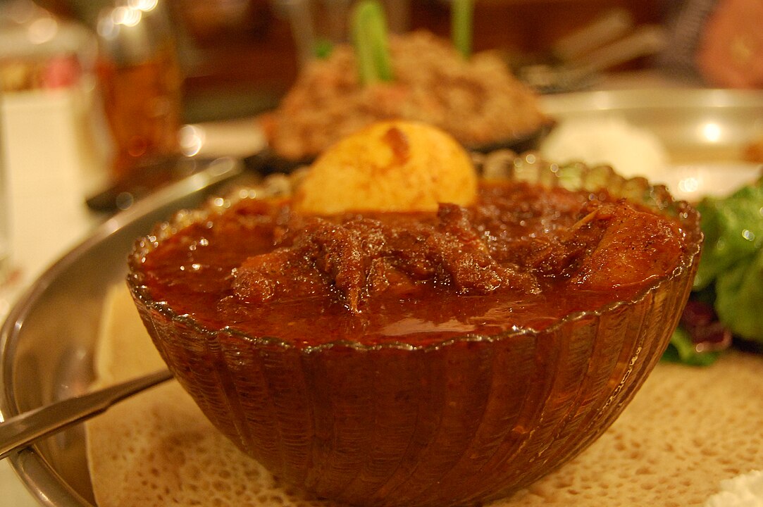 Etiópia - Doro Wat: Um ensopado apimentado de frango feito com berbere, uma mistura de especiarias rica em pimenta e ervas.
