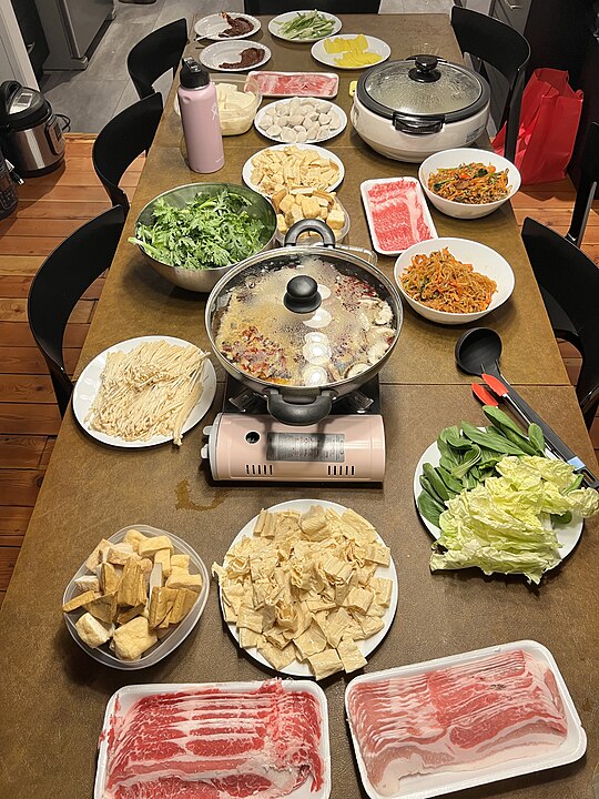 China - Hot Pot Sichuan: Uma panela fervente com caldo apimentado e aromático, onde se cozinham carnes e vegetais.
