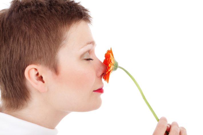 Mulher cheirando flor