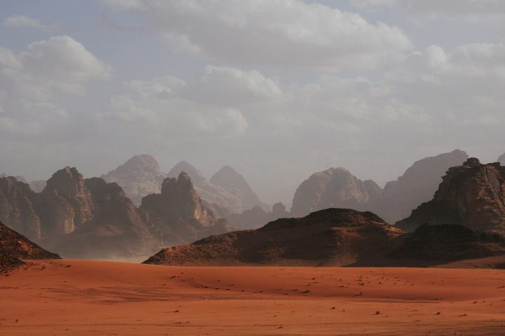 A superfície de Marte é composta por vastas planícies, vulcões gigantes, cânions profundos, dunas de areia e leitos de rios secos, indicando um passado geológico ativo e possivelmente úmido.