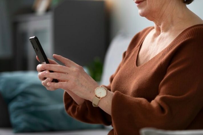 Idosa com celular na mão - Freepik