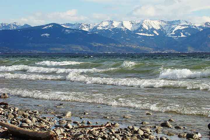 O entorno do lago é um espetáculo à parte, com uma paisagem que combina montanhas suaves, colinas e extensas áreas agrícolas, além de pequenas cidades históricas e vilarejos pitorescos.