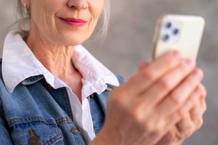 Idosa com celular na mão - Freepik
