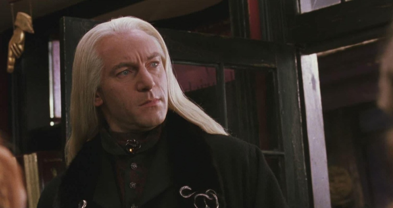 Quando Isaacs chegou ao set, foi surpreendido pelos planos da equipe de figurino e maquiagem. A proposta era um visual simples: terno risca de giz e cabelo castanho curto — praticamente igual ao dele — o que destoava completamente da imagem sombria e aristocrática que ele imaginava para Lucius Malfoy.