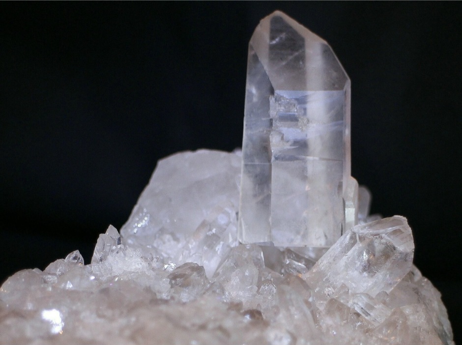 O quartzo cristalino, ou cristal de rocha, é transparente e muito utilizado em instrumentos ópticos. Seu alto grau de pureza e clareza o torna ideal para aplicações técnicas.