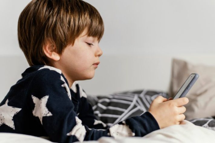 Criança olhando o celular - Freepik