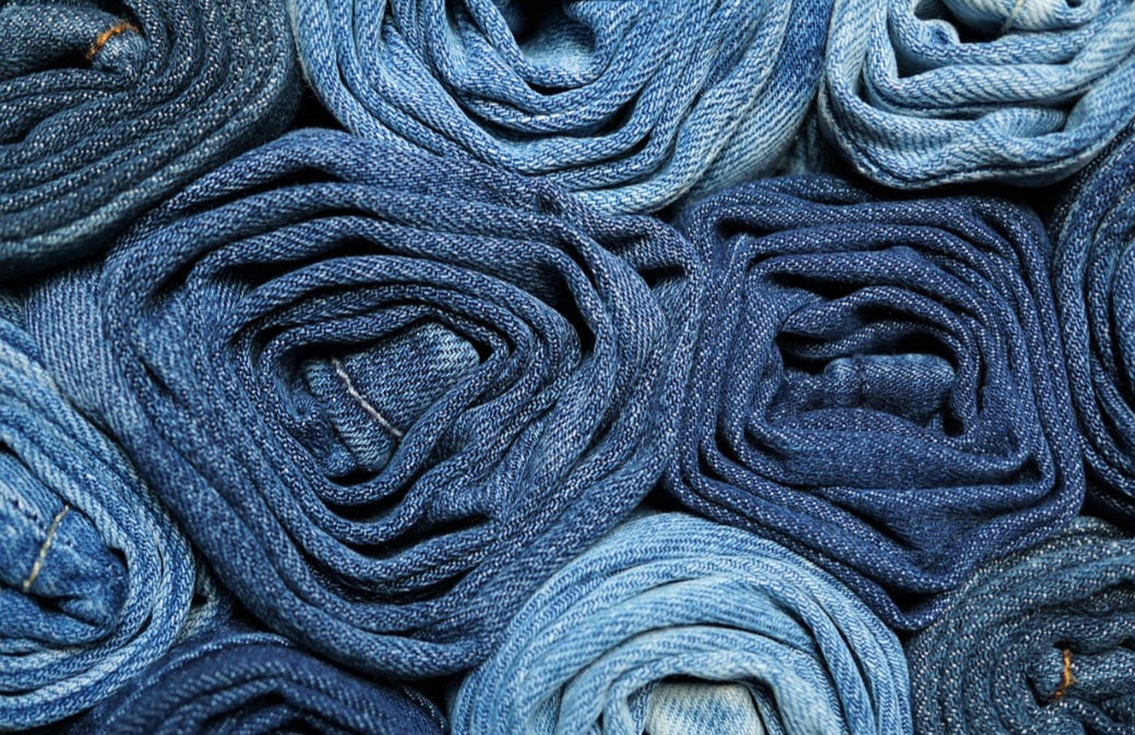 Presente nos guarda-roupas de praticamente todas as culturas e classes sociais, o tecido atravessou séculos e fronteiras, transformando-se de uniforme operário em ícone de moda global. 
