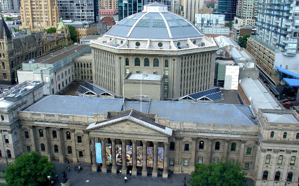 State Library Victoria, Melbourne, Austrália – fundada em 1854, ocupa um quarteirão inteiro em Melbourne com edifício neoclássico, pórtico majestoso e colunatas que evocam grandiosidade institucional.