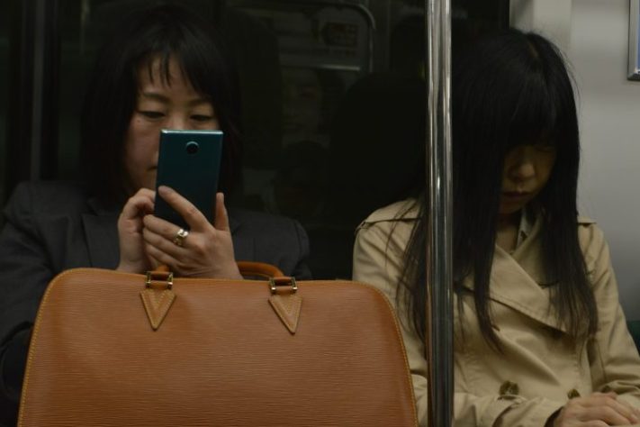 Mulher usando celular no Japão – Michal Ron Gavish/Unsplash