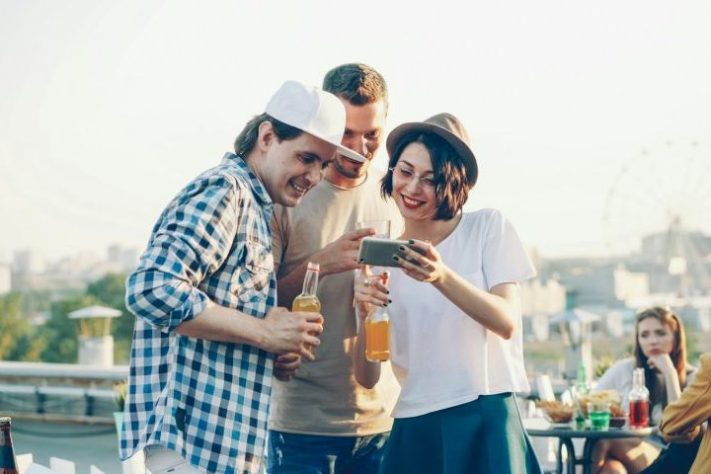 Grupo de amigos olha o celular - Vitaly Gariev/Unsplash