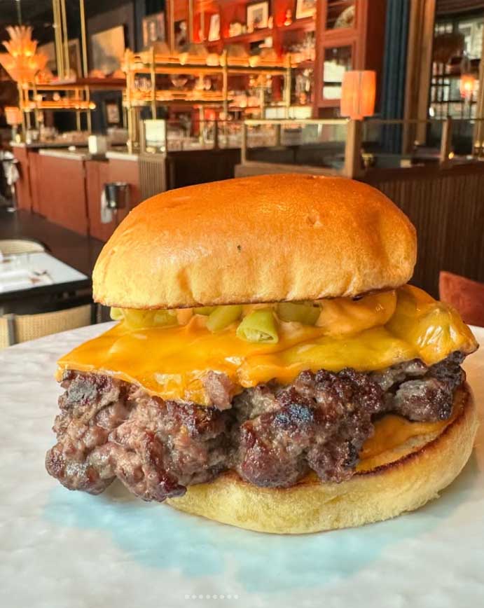 A publicação elogiou o equilíbrio entre os ingredientes e descreveu o resultado como “uma experiência de hambúrguer excepcionalmente refinada, com carnes suculentas e pão aromático e macio”.
