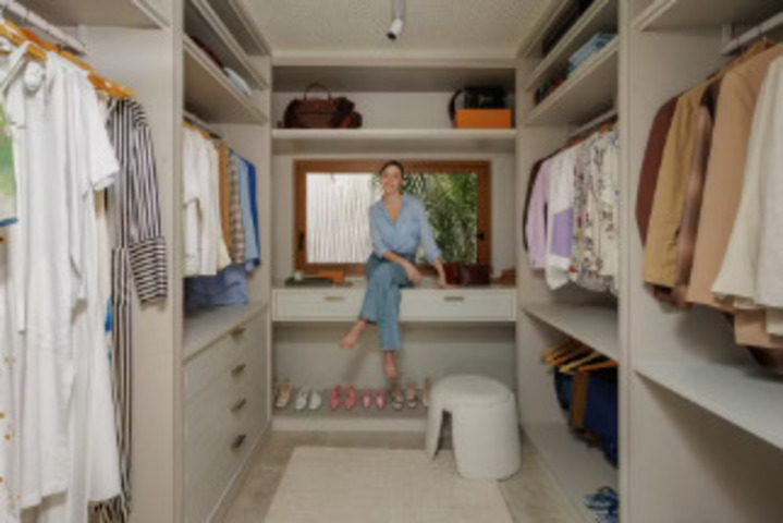 Um dos dormitórios foi transformado em closet e integrado à suíte máster, com espaço para maquiagem e cosméticos. No quarto, um móvel junto à TV virou penteadeira, e no banheiro, uma mureta funcional contorna o ambiente. Ladrilhos azuis criam divisão visual e reforçam o tom principal do décor.