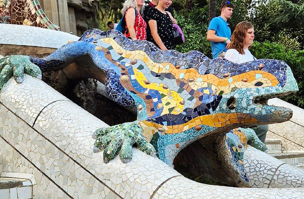 O dragão, também chamado de salamandra, é um dos símbolos mais fotografados do Parque Güell. Construído com a técnica de trencadís, mosaicos feitos de fragmentos cerâmicos, ele brilha em cores vivas. Localizado na escadaria principal, tornou-se ícone da cidade. Representa a força da natureza e a imaginação sem limites de Gaudí. É parada obrigatória para qualquer visitante.