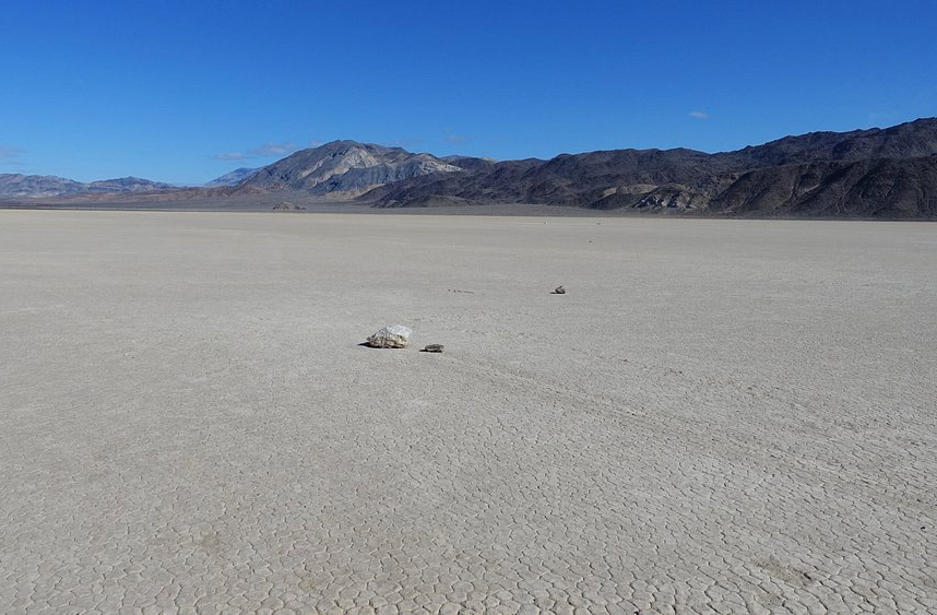 As pedras da Racetrack Playa variam de pequenos blocos a grandes rochas. Parecem deslizar lentamente pela superfície, deixando rastros sinuosos e paralelos. Por muito tempo, acreditou-se no envolvimento de forças misteriosas. Hoje sabemos que a ação ocorre em condições específicas de gelo, água e vento. Ver os rastros é como testemunhar uma obra de arte natural em constante transformação.