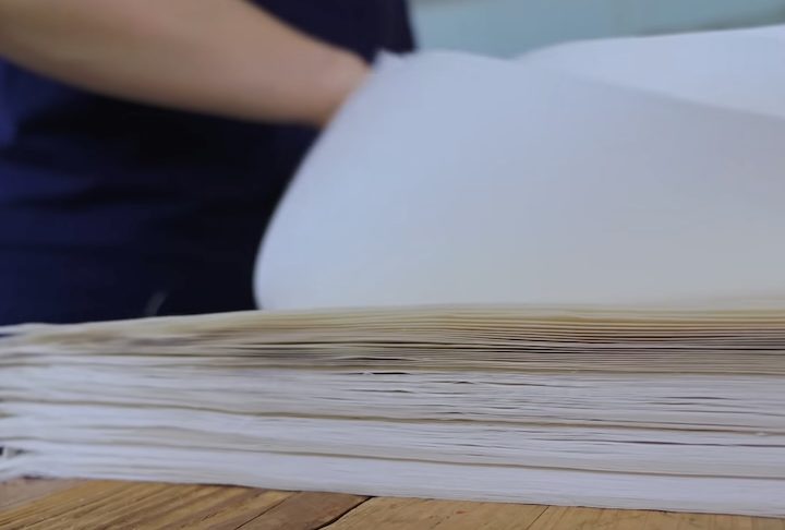 A etapa mais delicada é a separação das folhas, feita manualmente com extrema cautela para evitar rasgos, o que transformaria a obra-prima em perda total.