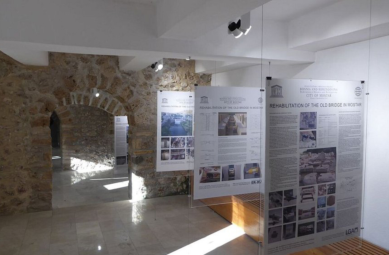 O museu apresenta documentos, fotos e objetos relacionados à construção, destruição e reconstrução da ponte. Uma seção subterrânea exibe achados arqueológicos e trechos originais da estrutura. A visita ajuda a compreender o impacto emocional da ponte na identidade local.