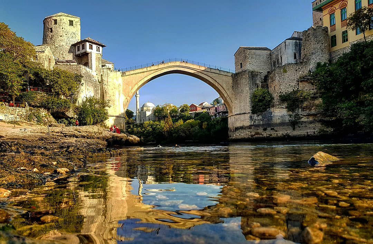 A ponte tem um arco único elegante que se estende sobre o rio Neretva, desafiando a engenharia da época. Construída originalmente com pedras locais chamadas tenelija, impressiona pela precisão e harmonia com a paisagem. A reconstrução utilizou técnicas tradicionais para preservar sua autenticidade histórica.

