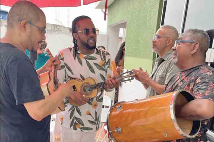 <p>Nascido em 25/12/1969 e criado em Pilares, bairro da Zona Norte carioca, ele carrega no próprio nome artístico a marca de suas raízes. Sua infância foi permeada por encontros musicais, o que lhe deu desde cedo a percepção de que o samba seria, além de uma paixão, um caminho de vida.</p>
<p>&nbsp;</p>
<p>&nbsp;</p>
