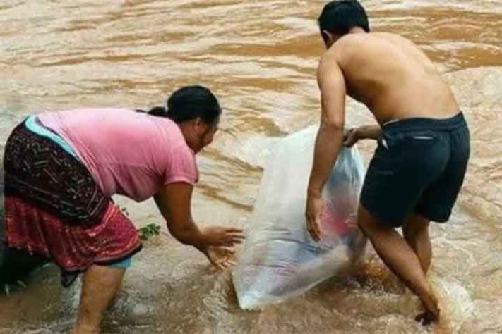 Em Huoi Ha pais colocam os filhos dentro de sacolas de nylon para cruzar o rio Nam Chim - Reprodução do Youtube