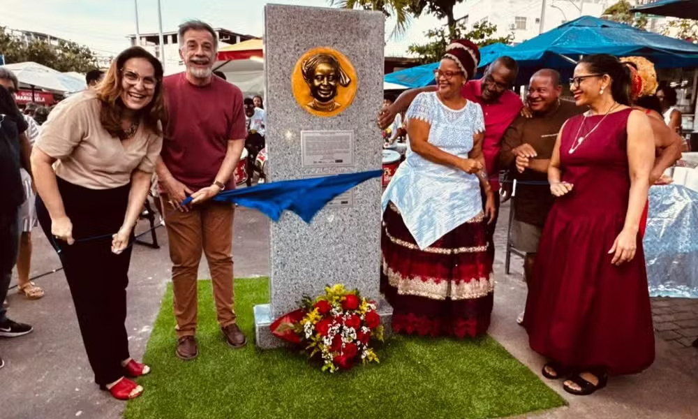 <p>Em Salvador, foi inaugurada no fim de 2025 a primeira efígie de uma baiana de acarajé, homenageando Cira do Acarajé, precursora de um dos tabuleiros mais famosos da cidade. O monumento foi erguido na praça Oxum Baeté, no bairro de Itapuã, onde fica uma das barracas que levam o nome da baiana. É memória viva em praça pública.</p>
<p>&nbsp;</p>
