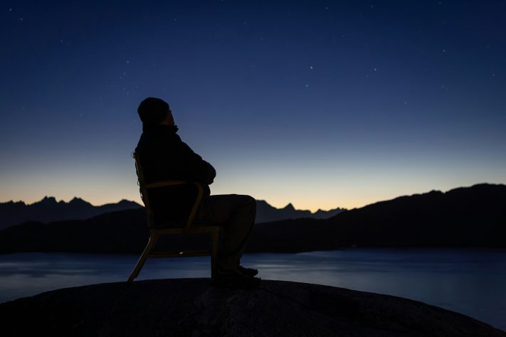 Homem sentado na Groenlândia – Nick Russill/Unsplash