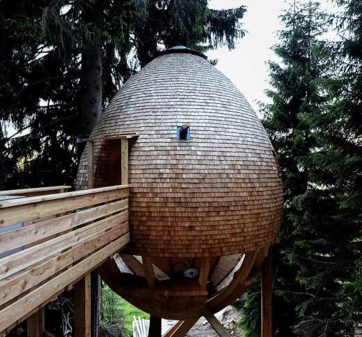 Situadas a 1.200 metros de altitude, com vista privilegiada para os Alpes italianos, essa casa foi esculpida em madeira de pinho-abeto e usa princípios de biomimética para se integrar à paisagem natural.