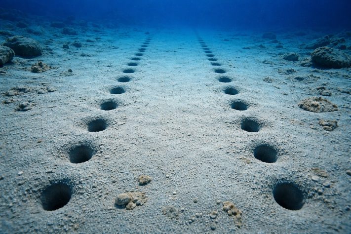 Cientistas encontram fileiras de buracos perfeitamente alinhados no fundo do oceano - Imagem gerada por IA