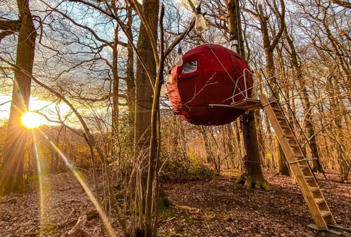 Feita com estrutura de alumínio, compensado e lona impermeável, essa casa em forma de esfera vermelha foi desenvolvida para se integrar à natureza.