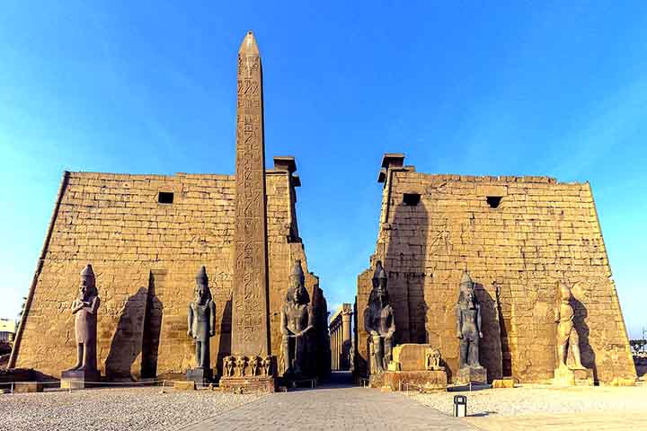 O templo de Luxor foi iniciado por Amenófis III e concluído por Ramsés II, tornando-se um dos mais importantes da região. Diferente de Karnak, era dedicado às celebrações da Opet, festival que reforçava a união entre o faraó e os deuses. Suas colunas e estátuas gigantes revelam a imponência da arquitetura egípcia, projetada para impressionar. O templo também servia como cenário para procissões religiosas que conectavam Luxor a Karnak. A função ritualística reforçava a centralidade da cidade de T