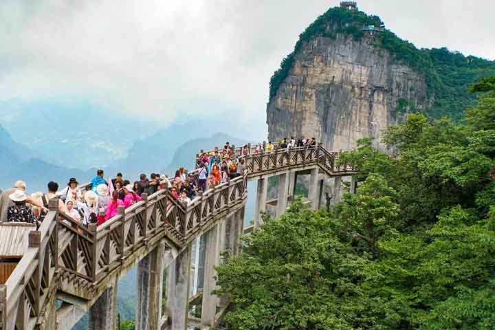 Explorar Zhangjiajie a pé é uma aventura inesquecível. Trilhas levam a miradouros suspensos, onde a vista das montanhas é de tirar o fôlego. Cada percurso revela novas perspectivas, reforçando a sensação de estar em um mundo fantástico, como se fosse Pandora.